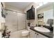 This bathroom features a shower-tub combo with a framed sliding glass door and a dark granite vanity at 891 Lucky Ln, The Villages, FL 32162