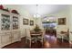 Light-filled dining room with hardwood floors, elegant furnishings, and seamless access to the living room at 891 Lucky Ln, The Villages, FL 32162