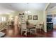 Dining room with hardwood floors, decorative chandelier, and views into the living room at 891 Lucky Ln, The Villages, FL 32162