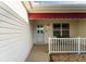 Covered front porch offers a cozy seating area with a charming bench at 891 Lucky Ln, The Villages, FL 32162