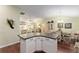 View of a kitchen island from the living room featuring an open layout to the dining area at 891 Lucky Ln, The Villages, FL 32162