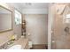 Bright bathroom with beige tile, a vanity with sink, a mirrored cabinet, and a glass-enclosed shower, offering a serene experience at 910 Rich Dr, Mount Dora, FL 32757