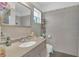 Well-lit bathroom featuring gray tile, a vanity with sink, and a mirrored cabinet, creating a functional and stylish space at 910 Rich Dr, Mount Dora, FL 32757