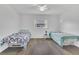 Simple bedroom with two twin beds, wood floors, a ceiling fan, and natural light creating a serene and functional space at 910 Rich Dr, Mount Dora, FL 32757