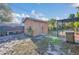 Image of a detached shed in the backyard with a gray door and a canopy alongside at 910 Rich Dr, Mount Dora, FL 32757