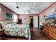 Comfortable bedroom with ceiling fan, wood floors, pink walls and a view of the entryway at 948 Dora Ave, Tavares, FL 32778