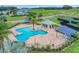 Aerial view showcases community pool, pool house, tennis courts and solar shade at 981 Fiesta Key Cir, Lady Lake, FL 32159