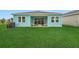 A view of the backyard with lush green grass and covered patio extends the living space outdoors at 981 Fiesta Key Cir, Lady Lake, FL 32159