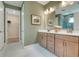 Well-lit bathroom with double vanity, quartz countertops, and access to the walk-in closet at 981 Fiesta Key Cir, Lady Lake, FL 32159