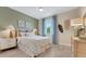 Well-lit bedroom features a comfortable bed, stylish curtains, decor and wood-look flooring, creating a relaxing atmosphere at 981 Fiesta Key Cir, Lady Lake, FL 32159
