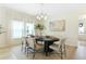 Elegant dining room with modern light fixture, neutral decor, and bright natural light from the large windows at 981 Fiesta Key Cir, Lady Lake, FL 32159