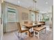 Bright dining area featuring a wooden table, unique light fixture, and a cozy bench seat at 981 Fiesta Key Cir, Lady Lake, FL 32159