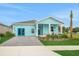 Inviting single-Gathering home with bright blue exterior, stone driveway, and a quaint covered front porch at 981 Fiesta Key Cir, Lady Lake, FL 32159