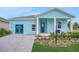 Charming single-story home with light blue siding, a covered front porch, and manicured landscaping at 981 Fiesta Key Cir, Lady Lake, FL 32159