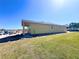 Side view of a single-story home showcasing a covered patio and spacious yard in a residential area at 981 Fiesta Key Cir, Lady Lake, FL 32159