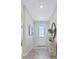 Entrance hallway with ceramic wood-look flooring, a decorative table, and art on the walls at 981 Fiesta Key Cir, Lady Lake, FL 32159