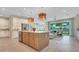 Open concept kitchen with stainless steel appliances, center island, and seamless flow to the living area at 981 Fiesta Key Cir, Lady Lake, FL 32159