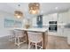Bright, modern kitchen with white cabinets, stainless steel appliances, large island, and pendant lighting at 981 Fiesta Key Cir, Lady Lake, FL 32159