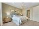 Serene bedroom with wood-look accent wall, chandelier, and large comfortable bed at 981 Fiesta Key Cir, Lady Lake, FL 32159