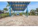 Relaxing seating area by the community pool, shaded by a solar panel structure at 981 Fiesta Key Cir, Lady Lake, FL 32159