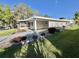 Charming home exterior with well-maintained landscaping, a cozy screened in porch, and an extended carport at 101 Royal Palm Dr, Leesburg, FL 34748