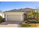 Beautiful single-story home featuring stone accents, a two-car garage and a well-manicured lawn at 1023 Timbervale Trl, Clermont, FL 34715