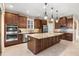 Spacious kitchen featuring wooden cabinetry, stainless steel appliances, and a large center island at 1023 Timbervale Trl, Clermont, FL 34715