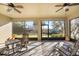 Relaxing screened-in lanai featuring ceiling fans, comfortable seating, and views of the landscaped backyard at 1023 Timbervale Trl, Clermont, FL 34715
