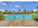 Resort-style pool featuring clear blue water, lounge cabanas, and lush tropical landscaping creating a vacation oasis at 1023 Timbervale Trl, Clermont, FL 34715