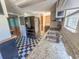 View of the kitchen with black and white floors and a large refrigerator at 103 Caroline Ave, Lady Lake, FL 32159