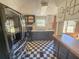 Kitchen with black and white tile, black fridge, and black cabinets at 103 Caroline Ave, Lady Lake, FL 32159