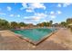 Large community pool surrounded by a brick patio, lush landscaping, and comfortable lounge chairs at 10301 Us Highway 27 # 84, Clermont, FL 34711