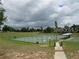 Community tennis court with a green playing surface, surrounded by a fence and green space at 10301 Us Highway 27 # 84, Clermont, FL 34711