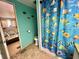 Vibrant bathroom with a whimsical fish-themed shower curtain and a view into the bedroom at 111 Azalea Trl, Leesburg, FL 34748