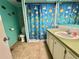 Colorful bathroom with a cheerful fish-themed shower curtain, a clean toilet, and a vanity sink at 111 Azalea Trl, Leesburg, FL 34748