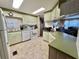 Well-lit kitchen features modern appliances and ample cabinet space with a view to the living room at 111 Azalea Trl, Leesburg, FL 34748