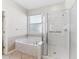 Bright bathroom featuring separate shower and tub with marble surround at 11759 Se 91St Cir, Summerfield, FL 34491