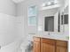 Bathroom with tub, toilet and wooden vanity at 11759 Se 91St Cir, Summerfield, FL 34491