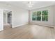 Large bedroom with hardwood-style floors and a large window viewing outside greenery at 11759 Se 91St Cir, Summerfield, FL 34491