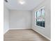 Simple bedroom with light walls, wood-look flooring, and a window providing natural light at 11759 Se 91St Cir, Summerfield, FL 34491