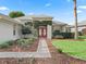 Charming front entrance with red double doors and mature landscaping creating a welcoming curb appeal at 11759 Se 91St Cir, Summerfield, FL 34491