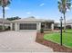 Beautiful home with a paver driveway, attached garage, and a well-maintained front lawn at 11759 Se 91St Cir, Summerfield, FL 34491