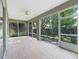 Spacious screened porch with tile flooring providing an outdoor living space with views of the backyard at 11759 Se 91St Cir, Summerfield, FL 34491