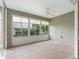 Bright sunroom with tile flooring, ceiling fan, and large windows offering views of the landscaped yard at 11759 Se 91St Cir, Summerfield, FL 34491