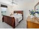 Cozy bedroom featuring a sleigh bed, soft carpeting, and a window with a view of the outdoors at 1417 Forest Acres Dr, The Villages, FL 32162