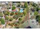 Aerial view of the property, outlined in red, next to a pond covered in vegetation, showcasing the landscape at 17108 Pine Ridge Dr, Umatilla, FL 32784