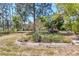 Well-maintained backyard with a hot tub, mature trees, and landscaping at 17108 Pine Ridge Dr, Umatilla, FL 32784