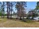 Expansive backyard with mature trees and views of a tranquil lake, perfect for outdoor activities at 17108 Pine Ridge Dr, Umatilla, FL 32784