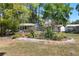Charming single-story home with a sunroom, lush landscaping, and mature trees at 17108 Pine Ridge Dr, Umatilla, FL 32784