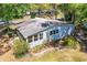 Charming home featuring a screened porch, complemented by mature landscaping and a classic white picket fence at 17108 Pine Ridge Dr, Umatilla, FL 32784